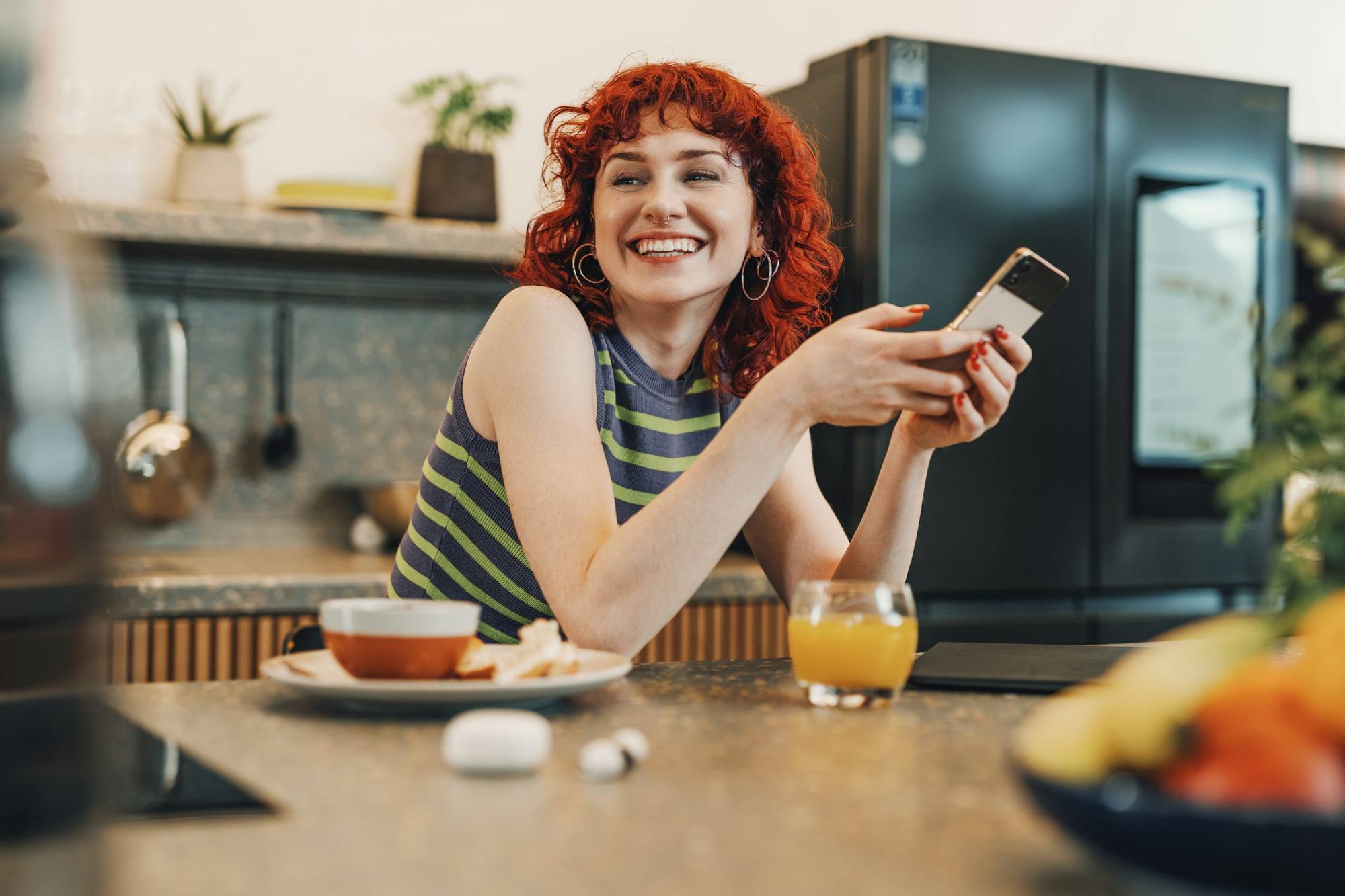 Девушка улыбается, читая сообщение в телефоне